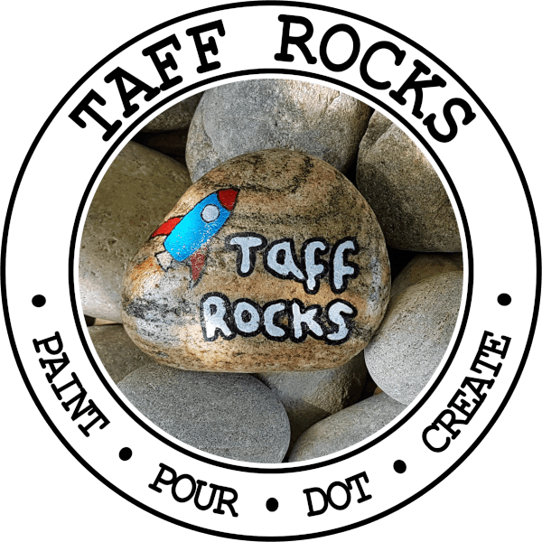 Taff Rocks logo featuring a painted stone with a rocket and the works 'Taff Rocks' surrounded by a smooth river rocks and a circular border reading paint, pour, dot, create